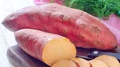 Süßkartoffeln, die auf einem Holzbrett mit einem Messer liegen: die eine Süßkartoffel ist aufgeschnitten, die andere ist im Ganzen | Bild: colourbox.com