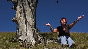 Frau hebt unter einem alten Baum die Arme | Bild: picture-alliance / Presse-Bild-Poss | Uta Poss
