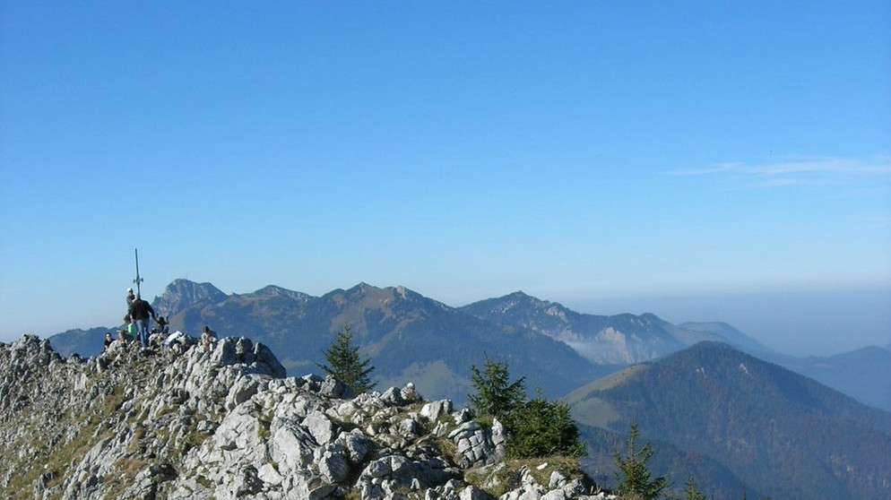 Der Gipfelgrat des Brünnsteins, im Vordergrund Wanderer, im Hintergrund blauer Himmel | Bild: BR / Klaus Schneider