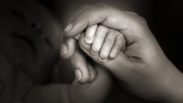 Hand einer jungen Mutter hält die Hand ihres Kindes | Bild: picture-alliance/dpa/Zentralbild/Hans Wiedl