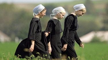Three Amish girls walk through a field on their way to a prayer service in Nickel Mines, PA, USA. | Bild: picture alliance / abaca | Philadelphia Inquirer/TNS/ABACA