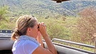 Eindrücke aus der Serengeti und dem Ngorongo-Krater: Drei Touristen beobachten das Wildleben vom einem Fernglas | Bild: BR/Till Ottlitz