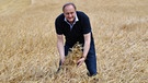 Joachim Rukwied, der Präsident des Deutschen Bauernverbandes im Juli 2016 auf einem Getreidefeld | Bild: picture-alliance/dpa