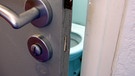 Blick durch einen Türspalt auf eine Toiletten-Schüssel | Bild: colourbox.com