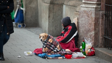 Ein Bettler sitzt mit seinem Hund am Kircheneingang in München im Winter | Bild: BR/ Volker Schmidt