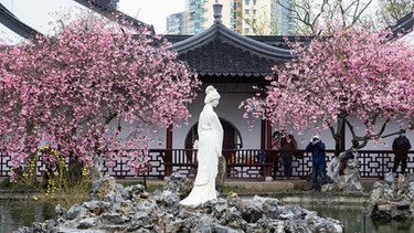 Blühender chinesischer Garten mit Frauenstatue in Jiangsu im Osten Chinas. | Bild: picture alliance / Su Yang / Costfoto | Su Yang / Costfoto
