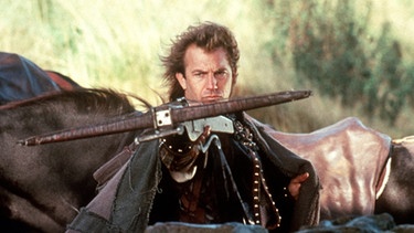 evin Costner als Robin of Locksley alias Robin Hood mit einer Armbrust in einer Szene des US-Films "Robin Hood - König der Diebe", der 1991 ins Kino kam.  | Bild: picture-alliance/dpa
