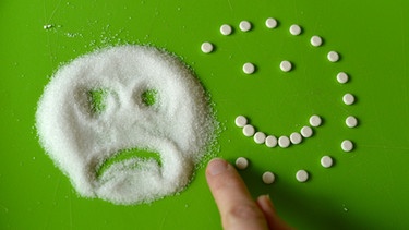 Zucker und Süßstoff die zu Gesichtern geformt sind | Bild: picture-alliance/dpa