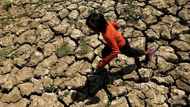 Philipinisches Kind geht durch eine von Dürre ausgetrockneten Landschaft. | Bild: picture alliance / dpa | Francis R. Malasig