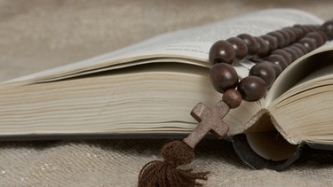 Ein kleines Kreuz liegt über Bibel | Bild: colourbox.com