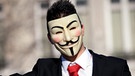 Mann im Anzug mit Guy-Fawkes-Maske, dem Symbol für die Freiheit, mit erhobenem Zeigefinger | Bild: picture-alliance/dpa
