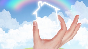 Hand hält silhouette von Haus vor Himmel mit Regenbogen | Bild: colourbox.com