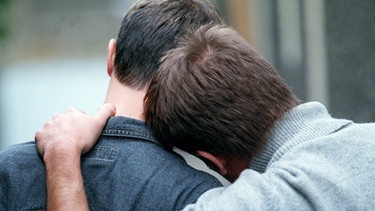 Ein Mann lehnt sich an die Schulter eines anderen Mannes an | Bild: colourbox.com