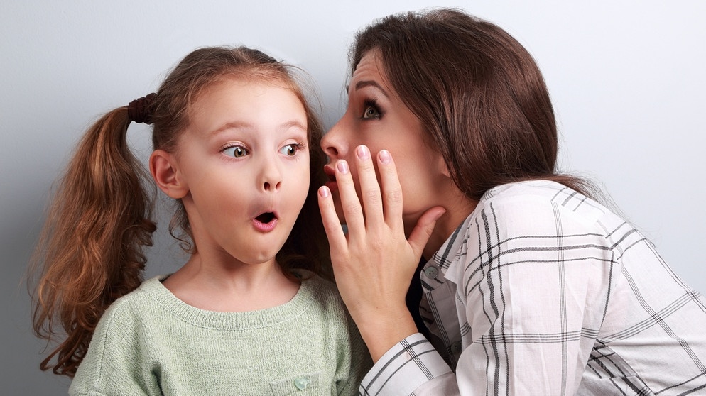 Mutter flüstert der kleinen erschrockenen Tochter etwas ins Ohr | Bild: colourbox.com