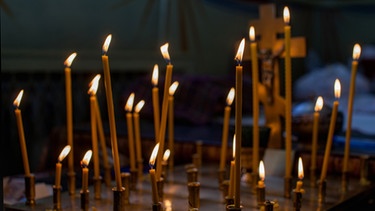 Kerzen vor einem Kreuz | Bild: colourbox.com