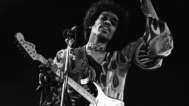 Jimi Hendrix auf der Bühne mit Gitarre | Bild: picture-alliance/dpa