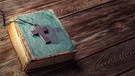 Kreuz liegt auf einem Buch | Bild: colourbox.com