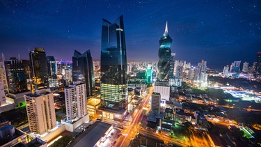 Eine hell erleuchtete Großstadt bei Nacht. | Bild: stock.adobe.com/mariana_designer