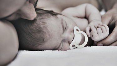 Vater kuschelt mit Baby | Bild: picture-alliance/dpa