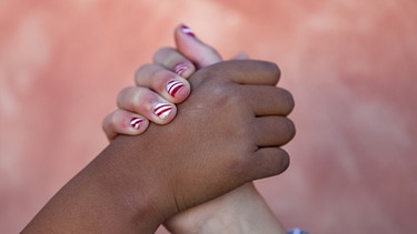 schwarze und weiße Hand greifen sich | Bild: colourbox.com