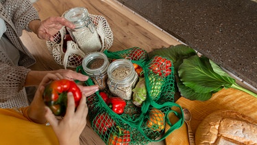 Zwei Personen packen eingekauftes Gemüse auf einem Tisch aus. | Bild: picture alliance / Westend61 | ME Lukashevich