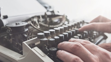 Person tippt auf Schreibmaschine (70er-Jahre) | Bild: picture-alliance/dpa