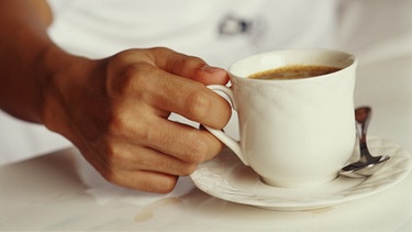 Mensch mit einer Kaffeetasse in der Hand | Bild: picture-alliance/dpa