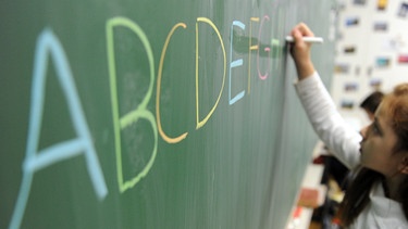 Eine Schülerin einer zweiten Klasse schreibt am 19.10.2012 in einer Schule in Hamburg das ABC an die Tafel.  | Bild: picture-alliance/dpa