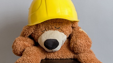 schlafender teddy mit helm | Bild: picture-alliance/dpa