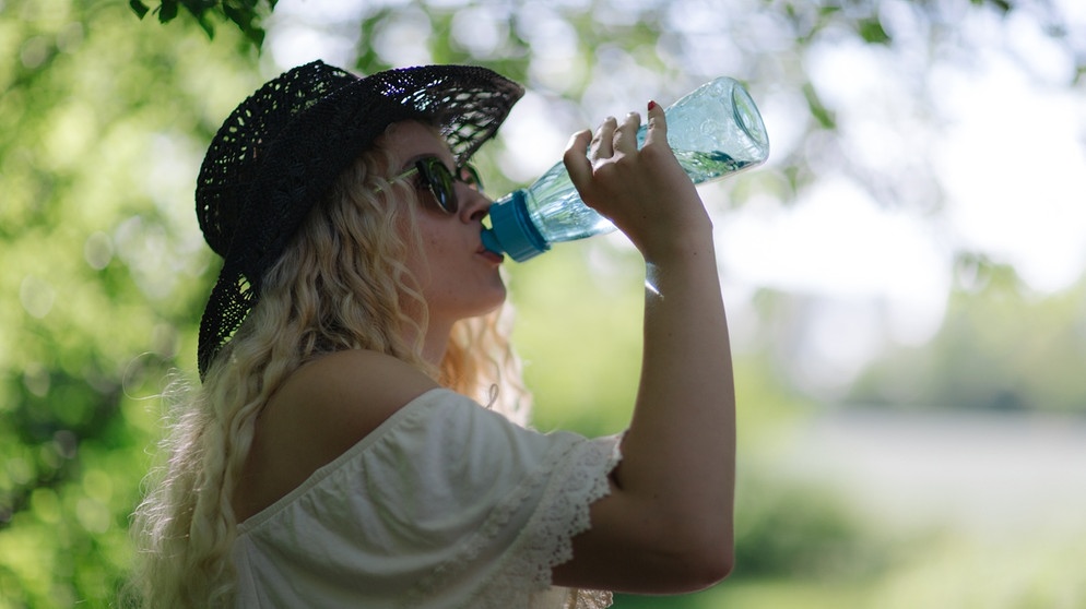 Eine junge Frau trinkt Wasser gegen die Sommerhitze. | Bild: BR/Sylvia Bentele