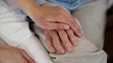 Pflegerin hält die Hand einer Seniorin. | Bild: BR/Fotografie/Johanna Schlüter