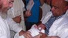 Beschneidungszeremonie mit Säugling Itamar, Menachem Fleischman und Pate Nissem - Symbolbild  | Bild: Igal Avidan