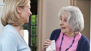 Nachbarschaftshilfe - Symbolbild (Frau bringt älterer Nachbarin die Zeitung) | Bild: picture-alliance/dpa