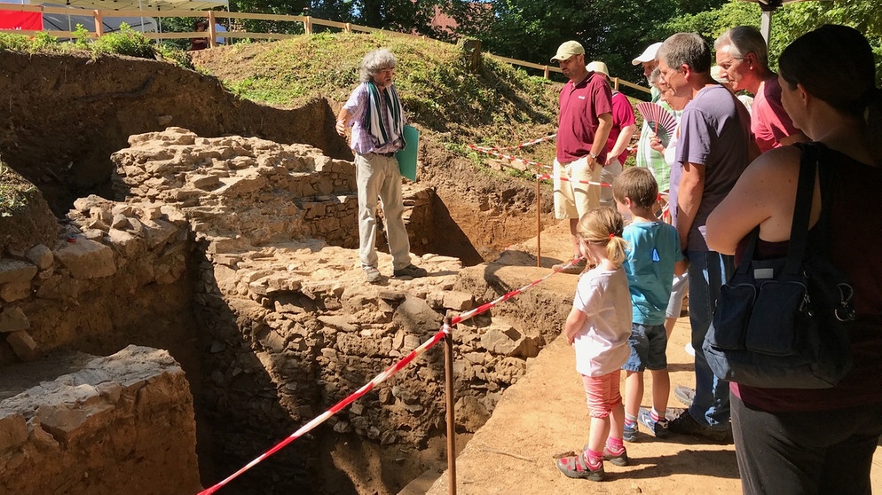 Bei den Ausgrabungen in Mömbris: Grabungsleiter Harald Rosmanitz zeigt Besuchern freigelegte Mauerreste | Bild: Ilona Hörath