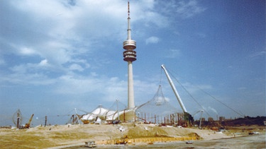 Bau der Wettkampfstätten im Olympiapark, August 1971: Geländeansicht vom Olympiapark mit der Zeltdachkonstruktion und dem Olympiaturm. | Bild: BR/Foto Sessner