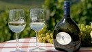 Ein Bocksbeutel mit Weingläsern und Weintrauben | Bild: picture-alliance/dpa