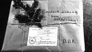 Mit einem Tannenzweig geschmückt ist ein Weihnachtspaket für einen Empfänger in der DDR. Der Hinweis "Geschenksendung keine Handelsware" durfte auf den Paketen nicht fehlen. | Bild: picture-alliance/dpa