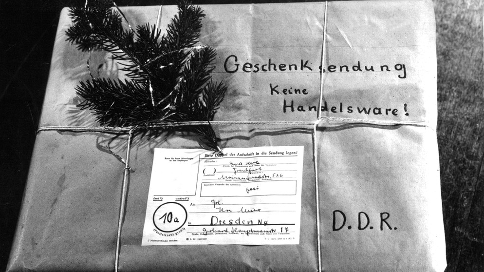 Mit einem Tannenzweig geschmückt ist ein Weihnachtspaket für einen Empfänger in der DDR. Der Hinweis "Geschenksendung keine Handelsware" durfte auf den Paketen nicht fehlen. | Bild: picture-alliance/dpa