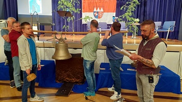 Bei einem Festakt in der Stadthalle von Eltmann wird die Wallburgglocke angeläutet. | Bild: BR-Wolfram Hanke