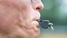 Schiedsrichter mit einer Trillerpfeife im Mund | Bild: picture-alliance/dpa