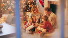 Symbolbild: Familie am Weihnachtsabend in ihrem Wohnzimmer | Bild: Digital Vision