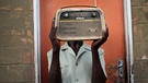 Mann hält Vintage Radio vor sein Gesicht. | Bild: picture-alliance/dpa
