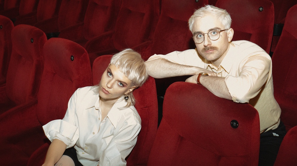 Gwen Dolyn von der Band Toyboys und Steffen Israel von Kraftklub sind die Tränen. Beide sitzen in einem Kinosessel hintereinander. | Bild: Selena Hamers