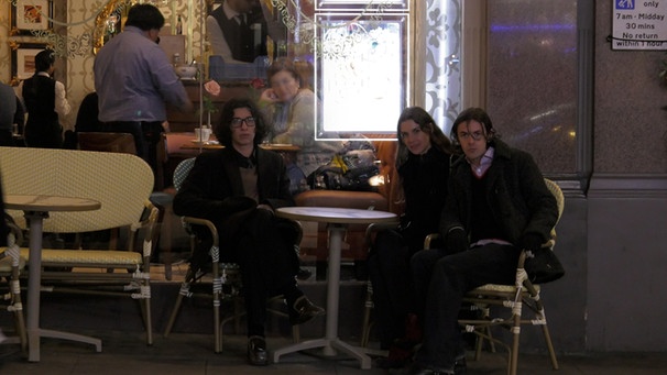Das Londoner Trio bar italia sitzt vor einem Cafe an einem Tisch | Bild: Simon Mercer