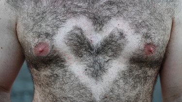 Ein Festivalbesucher hat sich ein Herz in sein Brusthaar rasiert. | Bild: picture alliance / Felix Kästle/dpa | Felix Kästle