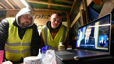 Gelbwesten schauen Macrons Rede auf einem Laptop | Bild: picture-alliance/dpa