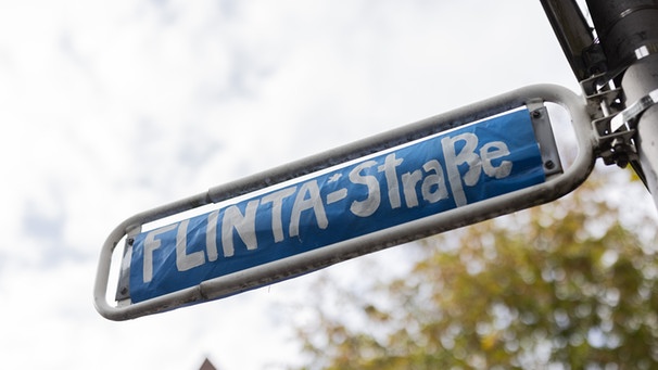 Aktivist*innen haben im Oktober 2021 das Straßenschild der Frauenstraße mit "Flinta*-Straße" überklebt. | Bild: picture alliance/dpa | Rolf Vennenbernd