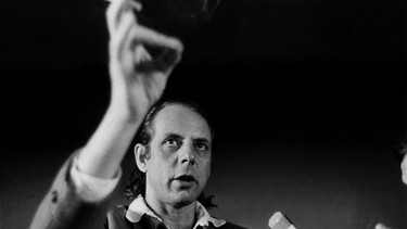 Der Komponist Karlheinz Stockhausen blickt nach oben, in seiner erhobenen Hand hält er eine Zigarette.  | Bild: picture alliance / Philippe Gras / Le Pictorium
