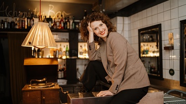 Schrifstellerin Katja Lewina, auf einem Tisch in einer Bar | Bild: Manuela Clemens