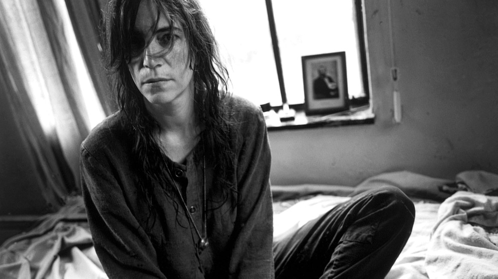 Patti Smith sitzt auf einem Bett | Bild: picture-alliance/dpa
